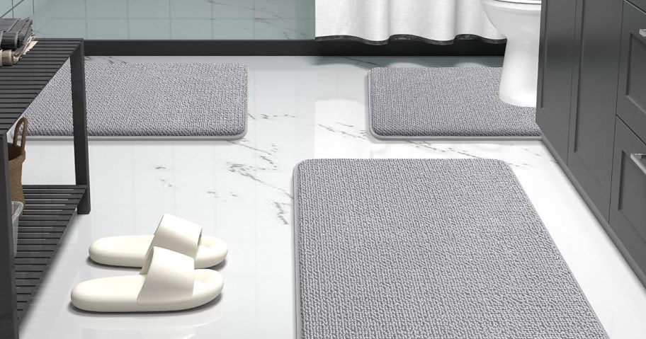 bathroom with white tile and grey bath mats