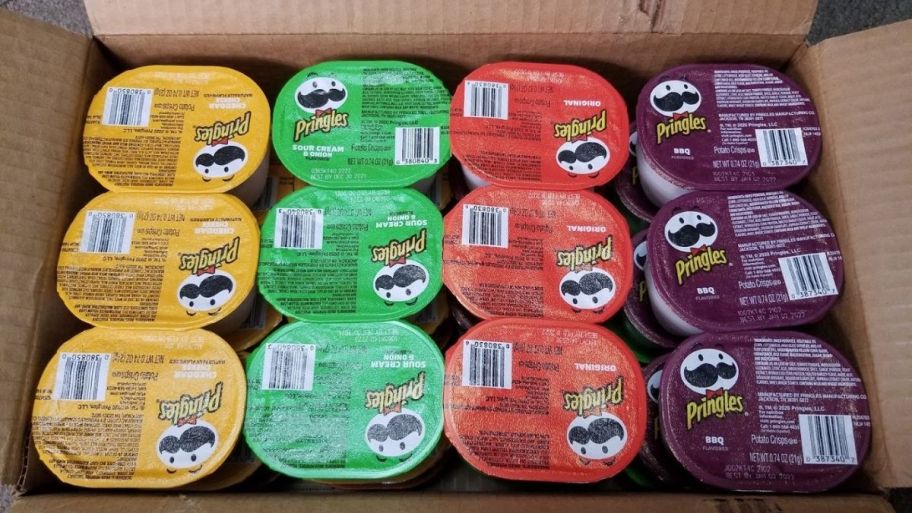 a card board box filled with pringle snack size chip cups. 