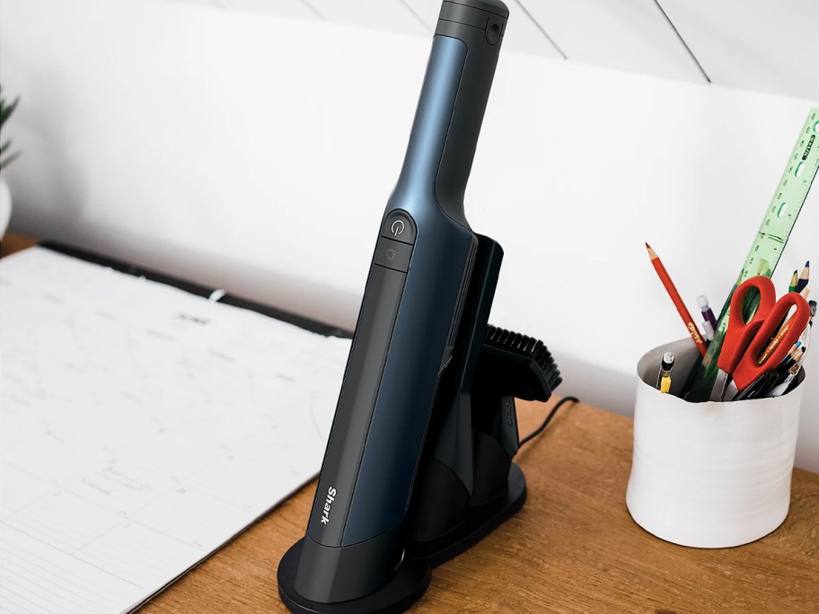 blue and black shark wandvac on charging dock 