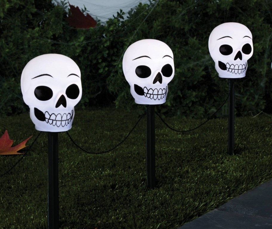 three skull path lights lining a sidewalk