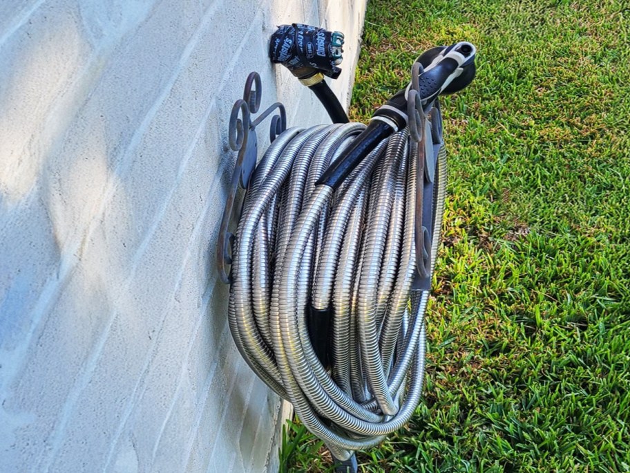 stainless steel garden hose attached to a brick wall