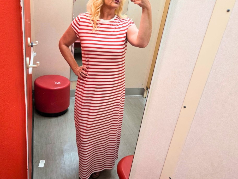 woman taking a selfie in a dressing room mirror wearing a red and white striped maxi dress