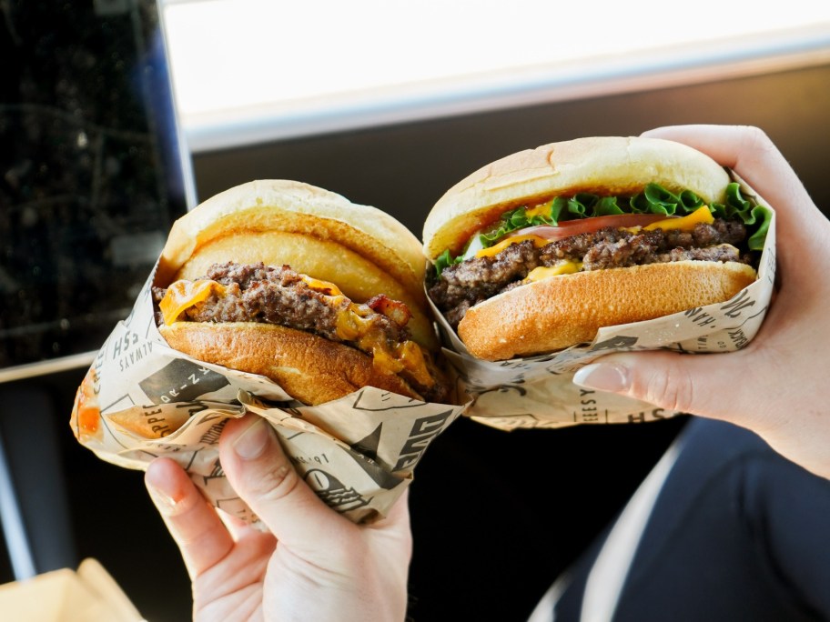 holding two burgers
