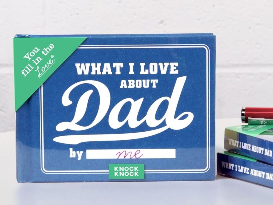 a book proped up on a counter top with 'what i love about dad' printed on the cover