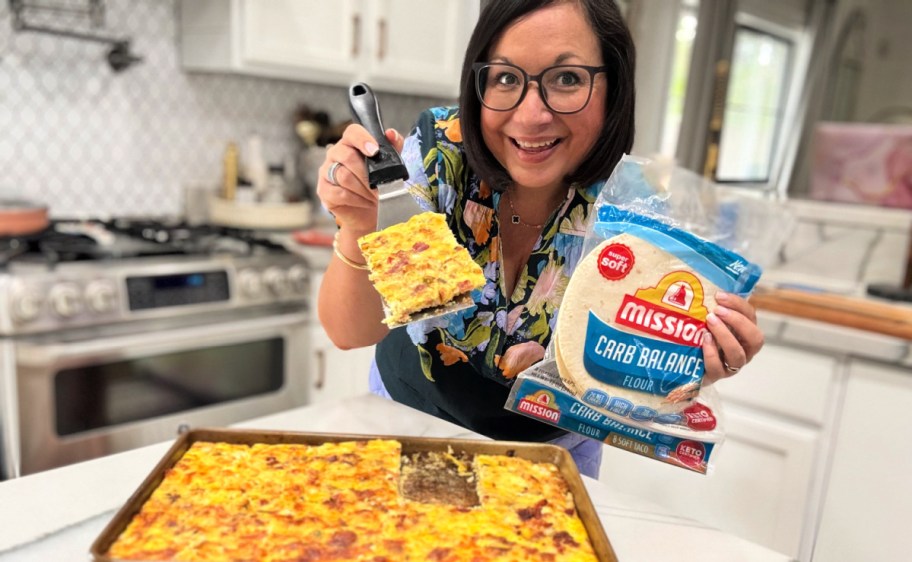 woman holding sheet pan breakfast burritos