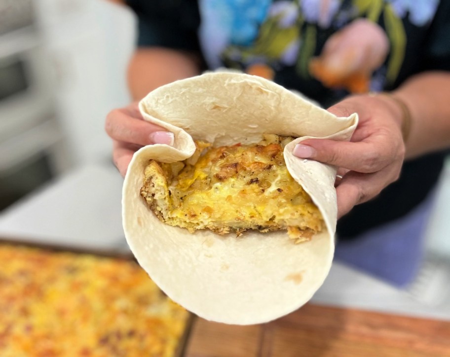 woman rolling up breakfast burritos 