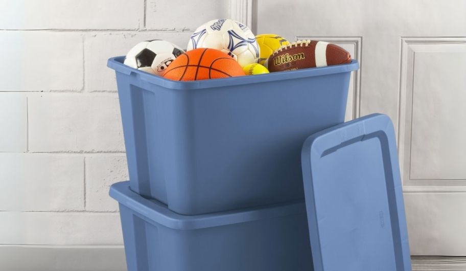 a blue 18 gallon tote filled with sports balls and stacked on top of another tote