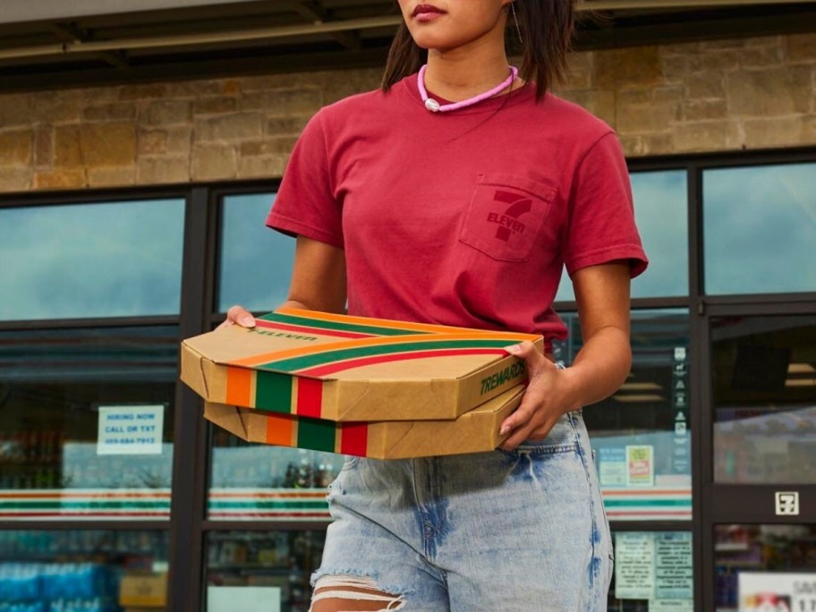 woman carrying 2 pizza boxes