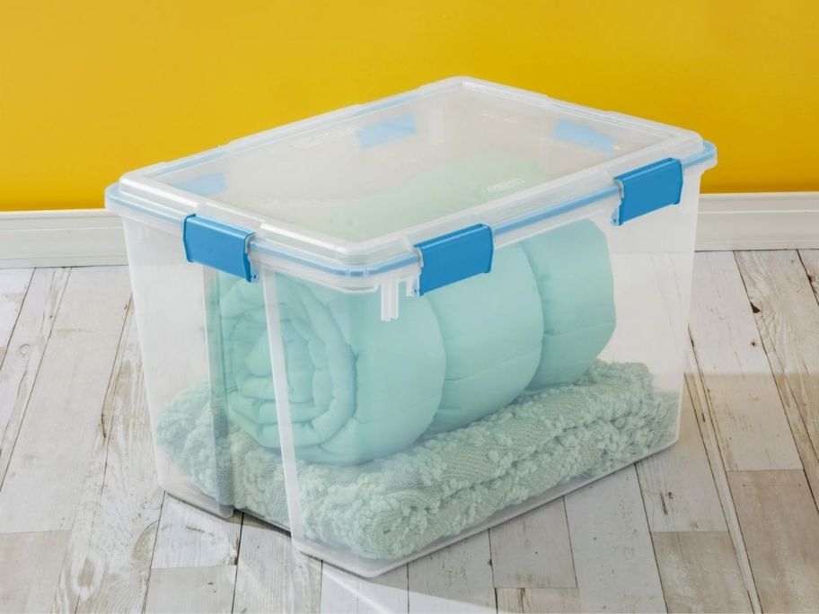80qt clearsterilite container with a rolled up comforter stored insde