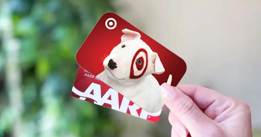 Hand holding Target gift card and AARP membership card