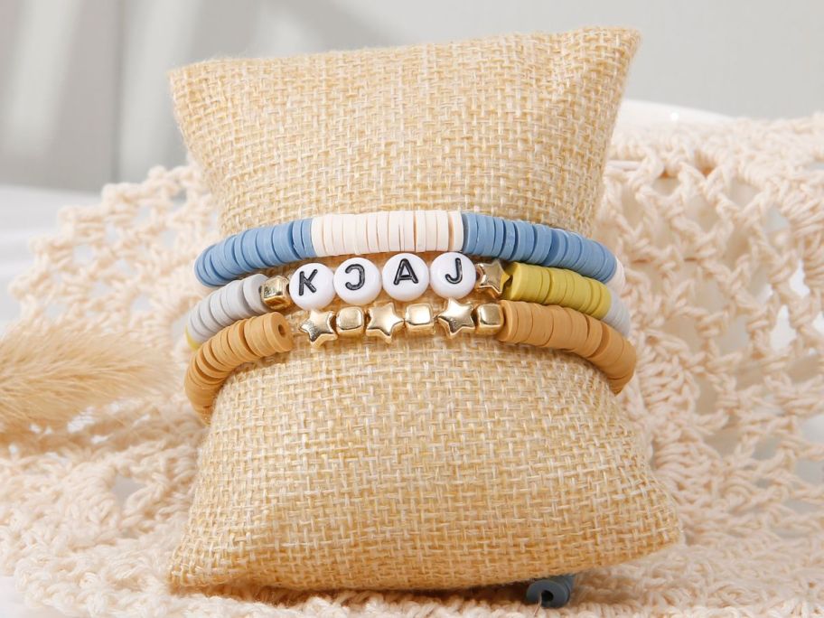 clay bead bracelets on a small pillow displayed on a table