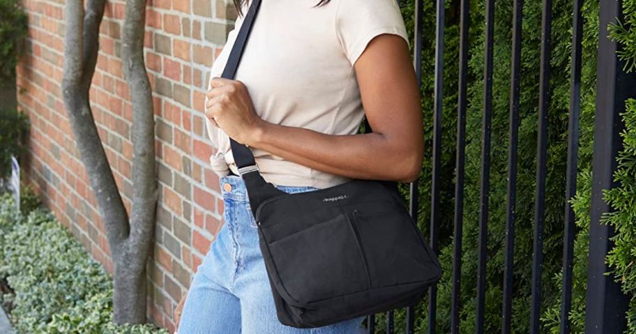 Woman wearing a black Baggallini Cross Over Crossbody Bag