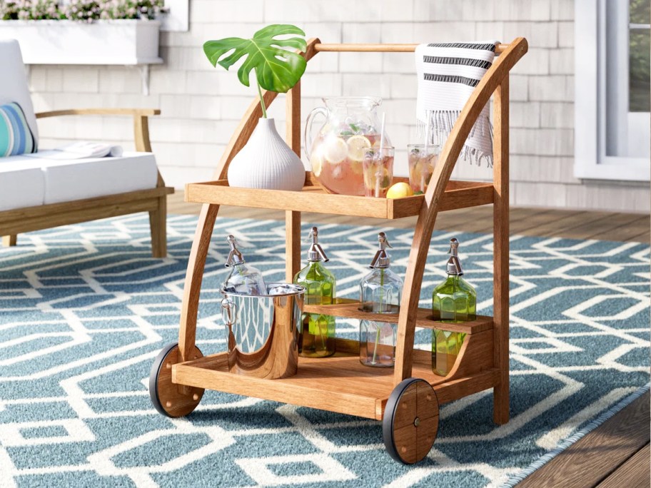 wood bar cart with various bottles and drinks on it