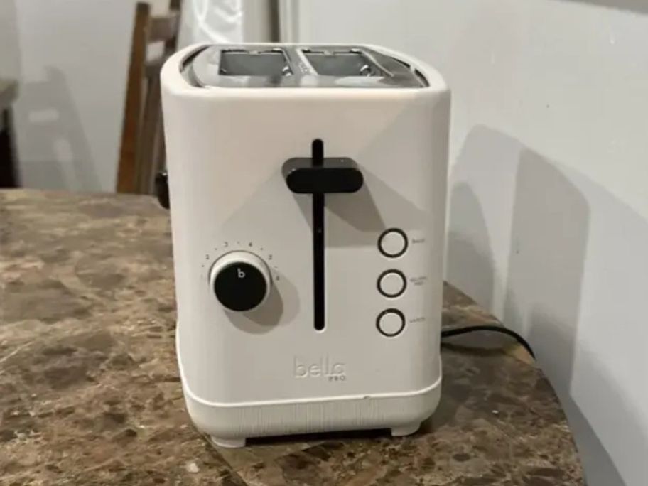 An off-white toaster on a table