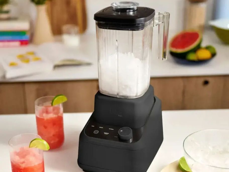 Bella Pro Series Blender filled with crushed ice next to two cups with pink drinks in them