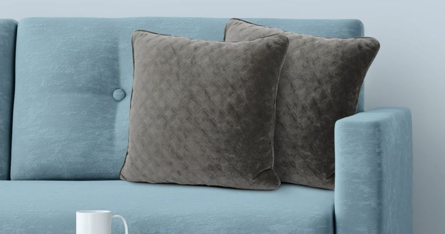A pair of throw pillows on a blue couch