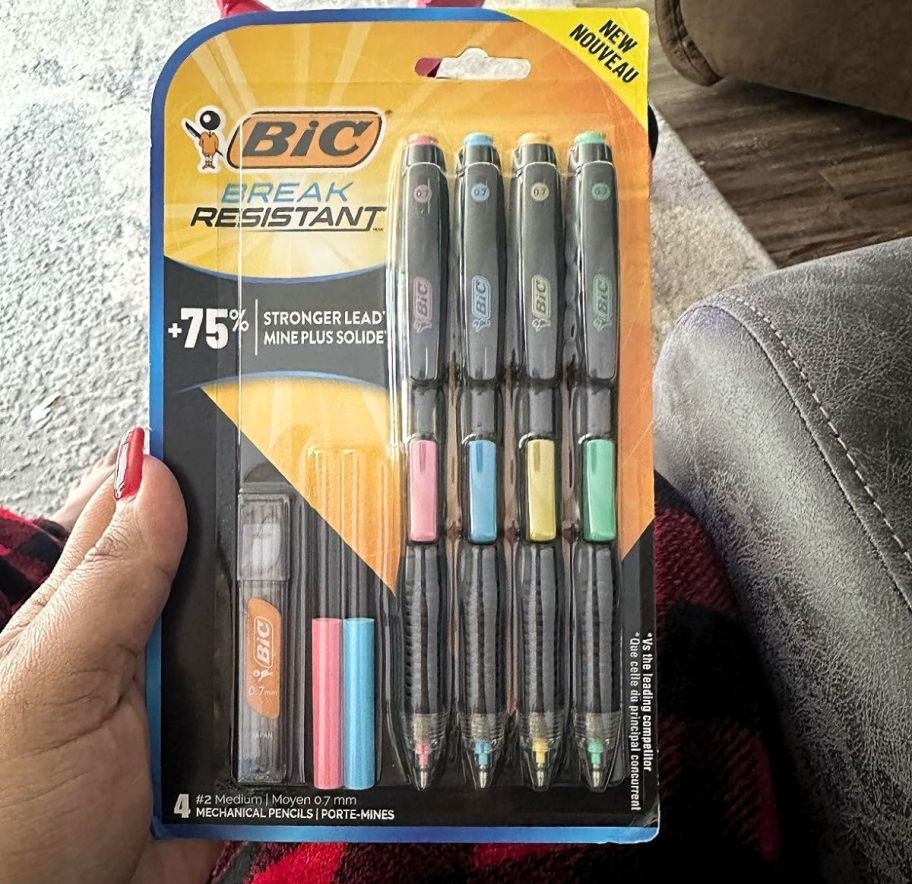 a womans hand holding a 4 count pack of BiC break resistant mechanical pencils