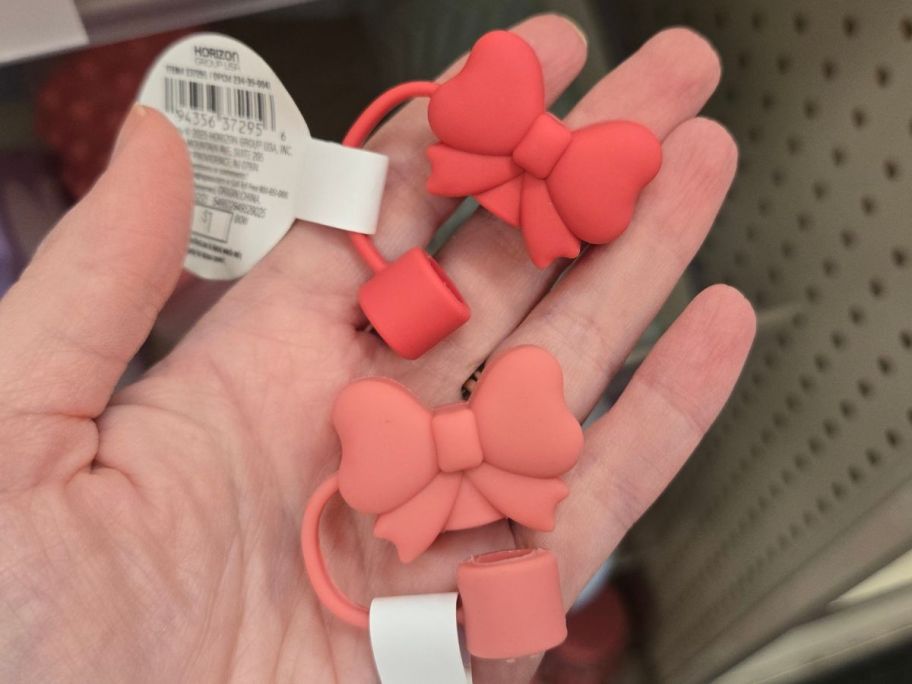 Hand howing two Bow Straw Toppers from Bullseye's Playground
