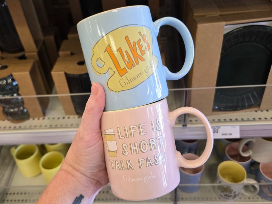 Hand holding two Gilmore Girl's Coffee Mugs