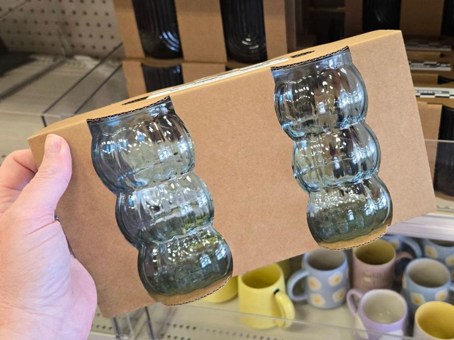 Hand holding a 2-pack of clear glass cups from Bullseye's Playground at Target