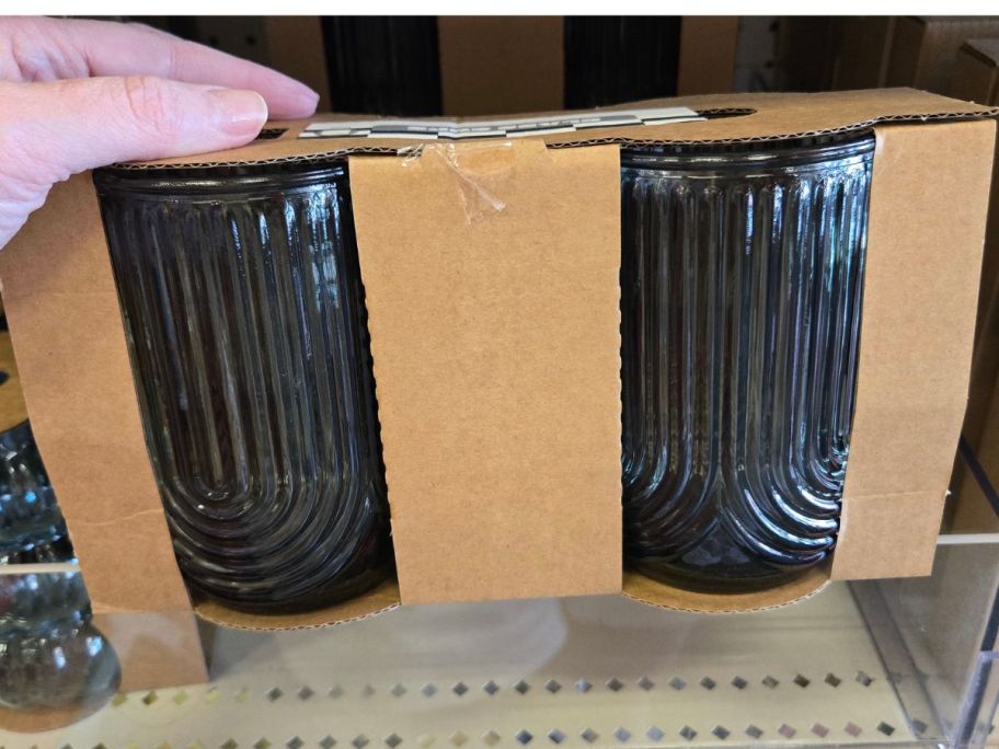 Hand holding a 2-pack of glasses from Bullseye's Playground at Target