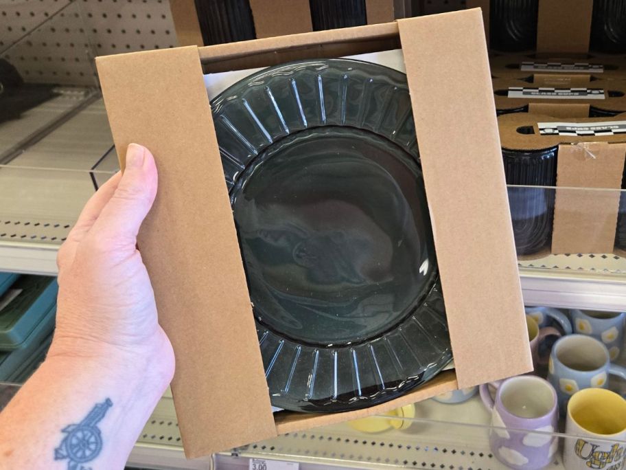 Hand holding a pack of green glass plates from Bullseye's Playground at Target