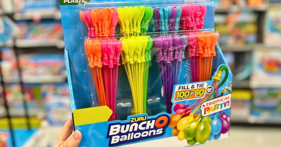 a womans hand holding a large package of bunch o balloons water balloons