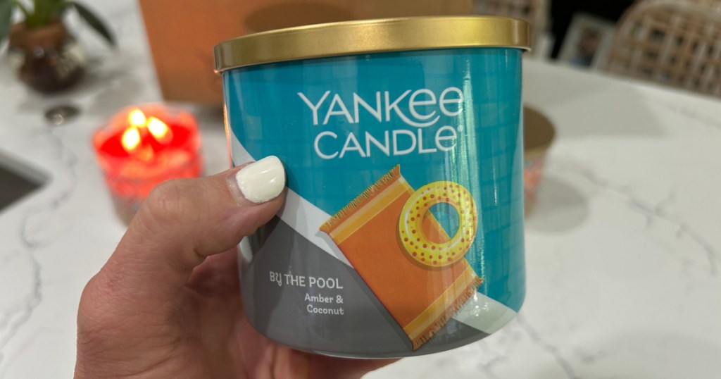 person holding up by the pool Yankee candle