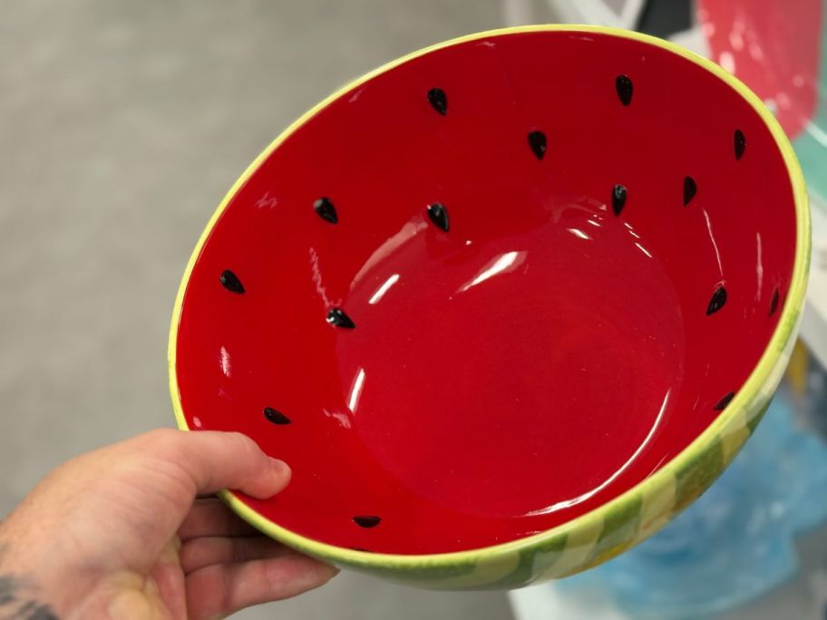 A person holding a bowl painted like a watermelon 