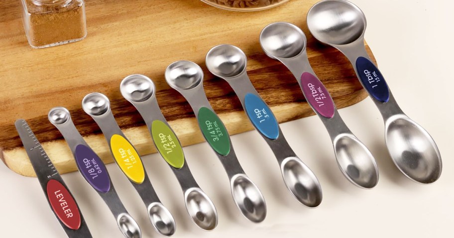 set of measuring spoons leaning against a cutting board