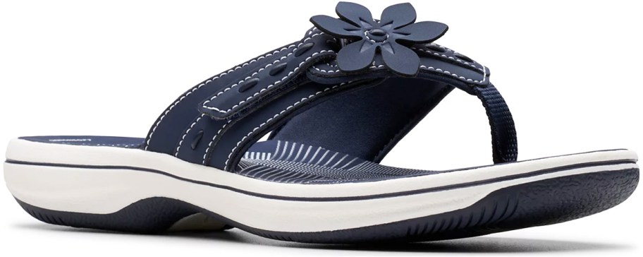 navy blue and white flip flop with flower on top