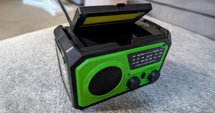 Green Emergency Radio sitting on a grey sofa