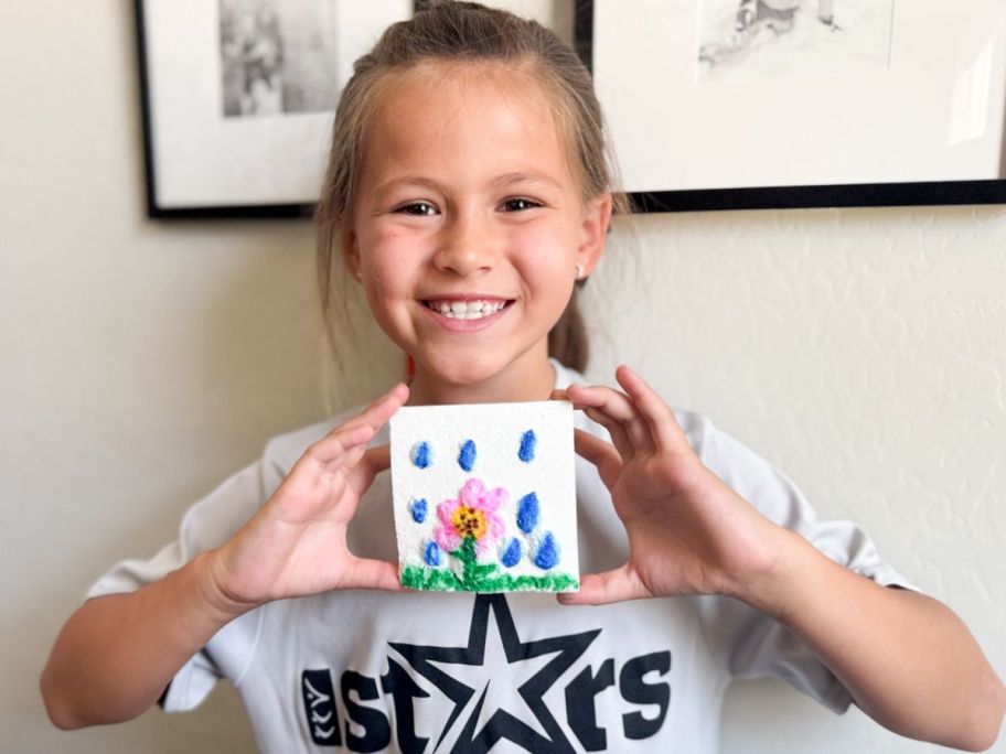 Little girl holding a picture made with foam paper