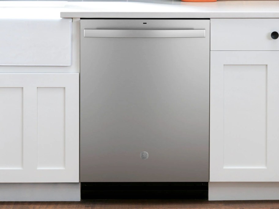 stainless steel dishwasher between white cabinets in kitchen