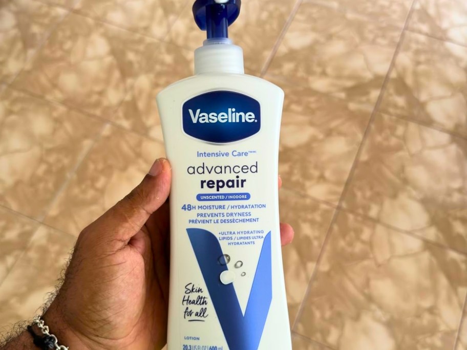 hand holding a large bottle of Vaseline Intensive Care Advanced Repair Lotion