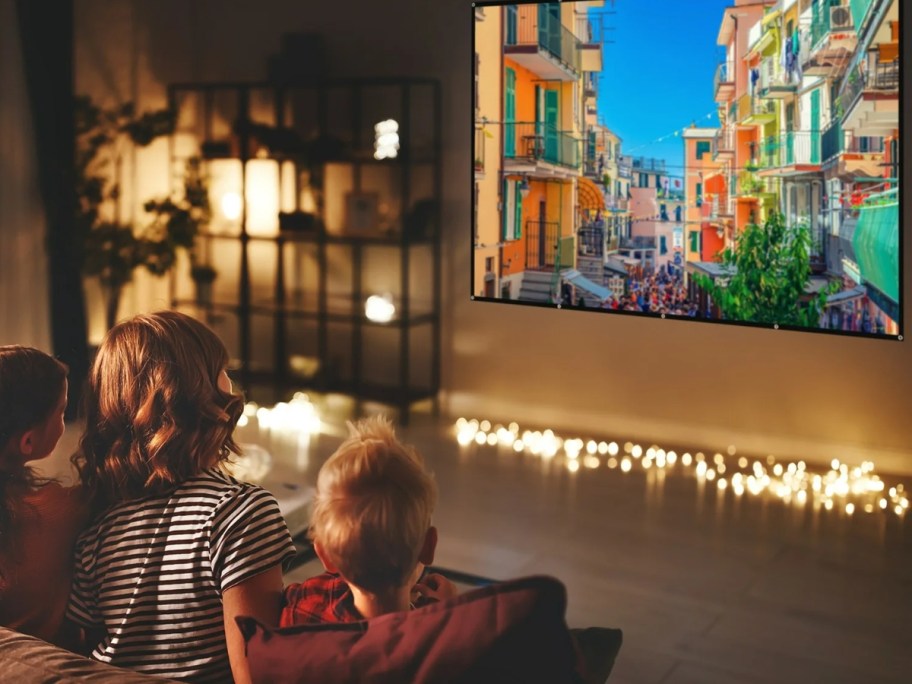 family watching a movie in a living room on a large projector screen