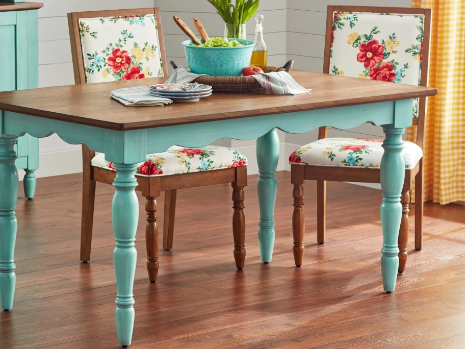 a dining table with a wood top and teal legs in a kitchen