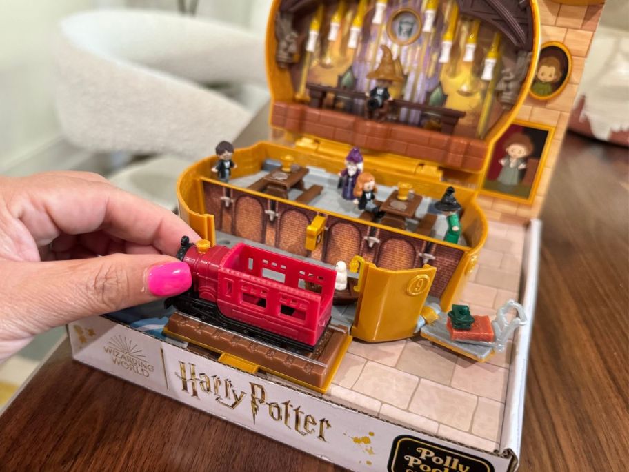 A woman playing with a Harry Potter toy