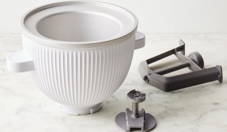 Ice cream attachment with the 3 items it comes with displayed on a marble counter top