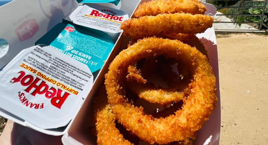Jack in the box onion rings in their box with 3 sauces on the side
