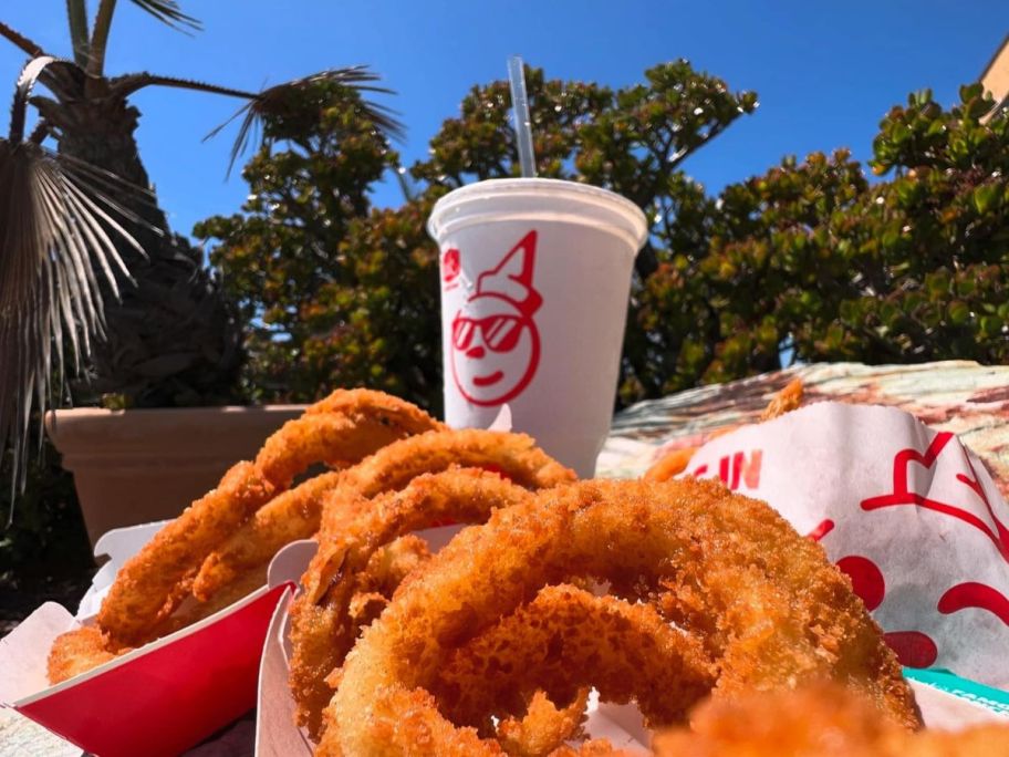 jack in the box soda displayed next to two boxes filled with onion rings outside 