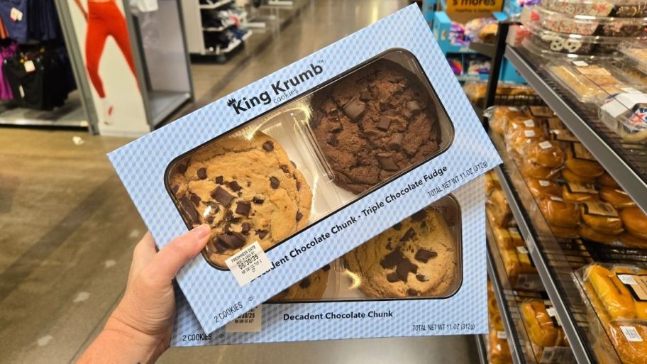 a womans hand holding two boxes of king krumb cookies