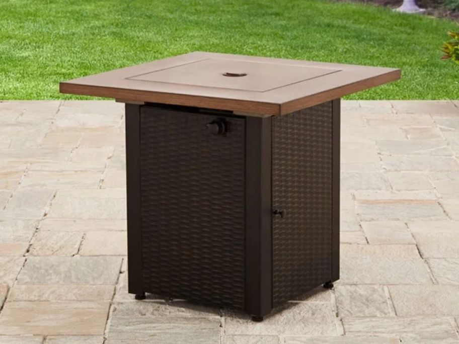 A brown, square fire pit on a patio