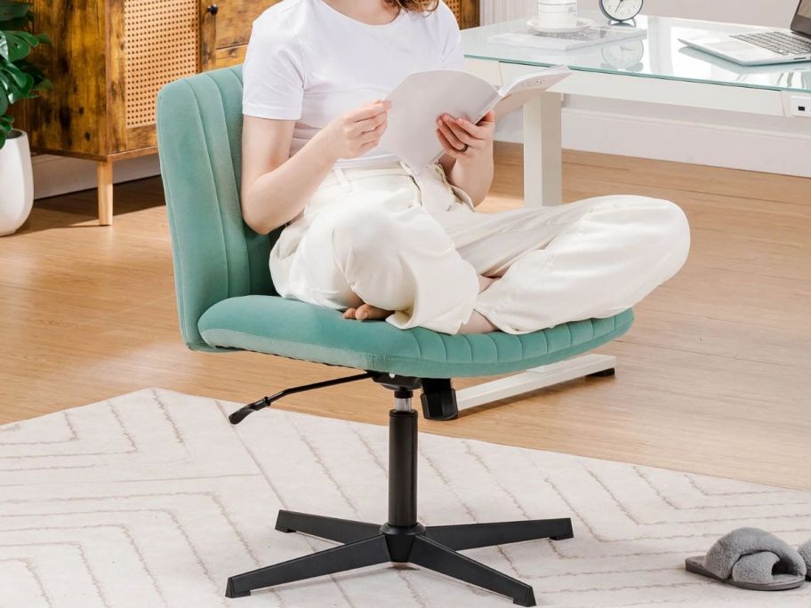 A woman sitting on an oversized green office chair in a home office