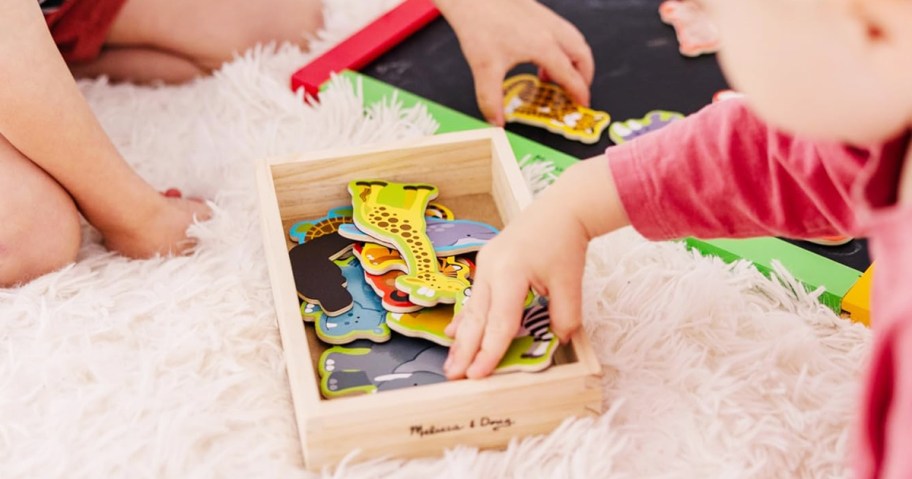 children grabbing animal magnets from wooden box