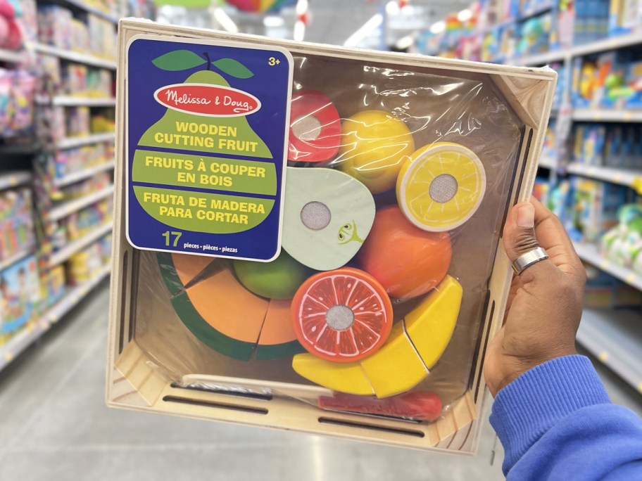 hand holding up Melissa & Doug Cutting Fruit Set in store