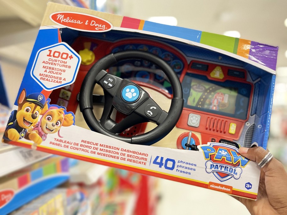 hand grabbing Melissa & Doug Paw Patrol Rescue Mission Wooden Dashboard from store shelf