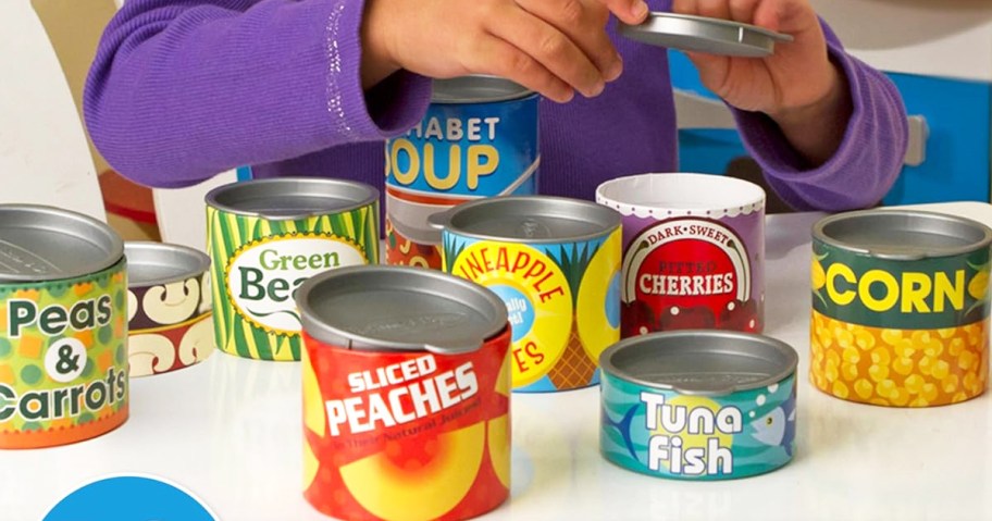 girl playing with toy grocery cans