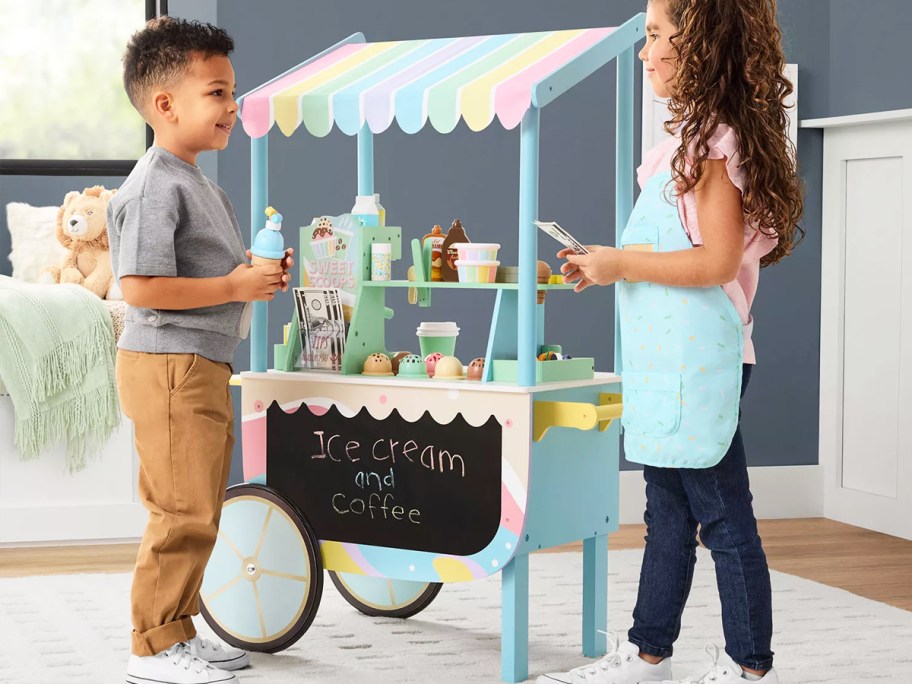 two kids playing with a colorful ice cream cart playset