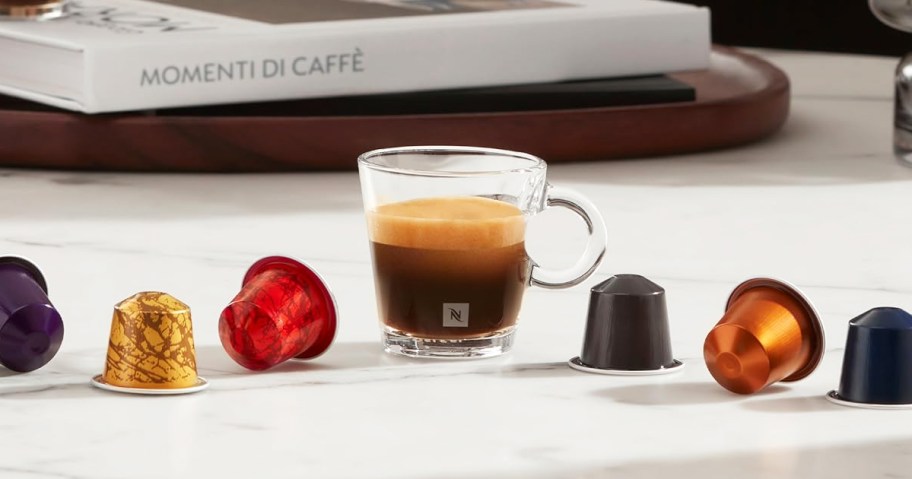 colorful Nespresso Pods on either side of a cup of espresso